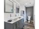 Bathroom with double sink vanity, with gray cabinets and hard surface countertop, and framed mirrors at 102 Royalty Cir, Sanford, FL 32771