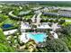 An aerial view of a luxurious community clubhouse with a large pool, manicured grounds, and nearby residential areas at 1067 Plantation Ln, Davenport, FL 33896