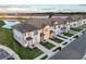 Aerial view of the community with modern townhomes and a peaceful lake setting at 1067 Plantation Ln, Davenport, FL 33896