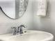 Bathroom with a white sink, chrome faucet, round mirror, and a hand towel at 1067 Plantation Ln, Davenport, FL 33896