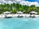 Wide angle view of a community pool with several lounge chairs, umbrellas, and tropical plants in the background at 1067 Plantation Ln, Davenport, FL 33896