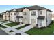 View of new construction townhomes featuring white siding, attached garages, and manicured lawns at 1067 Plantation Ln, Davenport, FL 33896