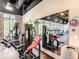 Well-lit gym with exercise equipment, brick walls, and a large mirror at 1067 Plantation Ln, Davenport, FL 33896