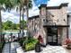 View of the community gym building's exterior with palm trees, landscaping, and a pool in the background at 1067 Plantation Ln, Davenport, FL 33896