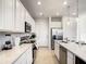 Modern kitchen boasts sleek white cabinetry, stainless steel appliances, and a functional layout, ideal for cooking at 1067 Plantation Ln, Davenport, FL 33896
