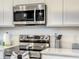 Modern stainless steel microwave and oven set against white cabinets and countertops at 1067 Plantation Ln, Davenport, FL 33896