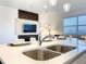 Modern kitchen with stainless steel sink and fixtures, and an open view to the living area at 1067 Plantation Ln, Davenport, FL 33896