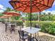 Patio seating with tables and umbrellas, overlooking lush greenery at 1067 Plantation Ln, Davenport, FL 33896
