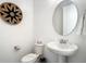 Clean powder room with modern fixtures, pedestal sink, round mirror, and stylish decor for guests at 1067 Plantation Ln, Davenport, FL 33896