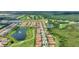 Aerial view of community near golf course, trees, and pond with fountain at 1082 Blackwolf Run Rd, Davenport, FL 33896