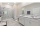 Bright bathroom with double vanity, large mirror, and frameless glass shower at 1082 Blackwolf Run Rd, Davenport, FL 33896