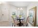 Cozy dining area with a round table, four chairs, an elegant chandelier, and a view of the outside at 1082 Blackwolf Run Rd, Davenport, FL 33896