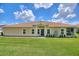 Charming single-story home featuring a well-manicured lawn, tile roof, and welcoming front entrance at 1082 Blackwolf Run Rd, Davenport, FL 33896