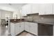 Modern kitchen featuring white cabinetry, stainless steel appliances, and stylish countertops with an adjacent dining area at 1082 Blackwolf Run Rd, Davenport, FL 33896