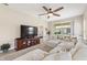 Spacious living room features a large TV, comfortable sectional sofa, and a view of the screened-in lanai at 1082 Blackwolf Run Rd, Davenport, FL 33896