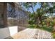 View of back porch featuring wooden floors and screened entryway leading to a well manicured lawn at 120 W Minnehaha Ave, Clermont, FL 34711