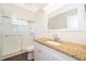 Updated bathroom features vanity with granite counters and a white shower with glass doors at 120 W Minnehaha Ave, Clermont, FL 34711