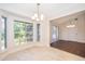 Bright dining room features large windows with backyard views, chandelier, and combination flooring at 120 W Minnehaha Ave, Clermont, FL 34711