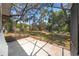 View from the screened patio out onto the spacious backyard featuring mature trees and clear blue skies at 120 W Minnehaha Ave, Clermont, FL 34711