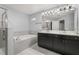 Stylish bathroom with double vanity, soaking tub, and glass-enclosed shower at 14160 Dove Hollow Dr, Orlando, FL 32824