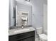 Bathroom featuring a granite countertop, a dark vanity, and an oversized mirror at 14160 Dove Hollow Dr, Orlando, FL 32824