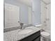 Bathroom featuring a granite countertop, a dark vanity, and tiled shower at 14160 Dove Hollow Dr, Orlando, FL 32824