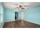 Bedroom with hardwood floor, ceiling fan, and blue accent wall at 14160 Dove Hollow Dr, Orlando, FL 32824