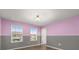 A cozy bedroom with pink and gray walls, natural light from the windows, and wood-look flooring at 14160 Dove Hollow Dr, Orlando, FL 32824