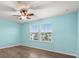 This bedroom has two windows, wood floors, and a ceiling fan at 14160 Dove Hollow Dr, Orlando, FL 32824