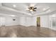 Spacious bedroom featuring modern tray ceilings, a ceiling fan, and stylish wood-look floors at 14160 Dove Hollow Dr, Orlando, FL 32824