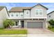 Charming two-story home featuring a stone facade, gray paint, and well-manicured landscaping at 14160 Dove Hollow Dr, Orlando, FL 32824