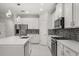 Modern kitchen boasts stainless steel appliances, white cabinets, quartz countertops, and island sink at 14160 Dove Hollow Dr, Orlando, FL 32824