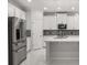 Modern kitchen boasts stainless steel appliances, white cabinets, quartz countertops, and island sink at 14160 Dove Hollow Dr, Orlando, FL 32824