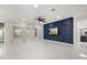 Bright living room features tile floors, and a unique textured blue accent wall with mounted television at 14160 Dove Hollow Dr, Orlando, FL 32824