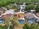 Home with a pool and solar panels is shown from above, surrounded by mature trees and neighborhood streets at 149 Imperial Oak Ct, Davenport, FL 33896