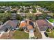 Expansive aerial view showcasing a suburban home with a pool and solar panels in a lush, green neighborhood at 149 Imperial Oak Ct, Davenport, FL 33896