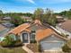 Aerial view of a single-story home with solar panels, surrounded by lush greenery and other residences at 149 Imperial Oak Ct, Davenport, FL 33896
