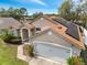 Aerial view of a single-story home with solar panels on roof, set amongst trees and residential neighborhood at 149 Imperial Oak Ct, Davenport, FL 33896