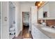 Hallway featuring bathroom and bedroom with wooden floors and a vanity with double sinks at 149 Imperial Oak Ct, Davenport, FL 33896