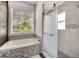 Bright bathroom featuring a soaking tub with mosaic tile surround and a walk-in shower with glass doors at 149 Imperial Oak Ct, Davenport, FL 33896