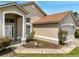 Close up of a charming front entrance with a white door and manicured landscaping at 149 Imperial Oak Ct, Davenport, FL 33896