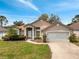 Inviting single-story home with a well-maintained lawn and an attached two-car garage at 149 Imperial Oak Ct, Davenport, FL 33896