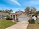 Inviting single-story home with a two-car garage and solar panels on the roof at 149 Imperial Oak Ct, Davenport, FL 33896