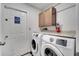 Well-lit laundry room with modern washer and dryer, storage cabinet, and practical countertop at 149 Imperial Oak Ct, Davenport, FL 33896
