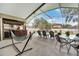 Relaxing screened-in patio featuring a tiki bar, outdoor dining area, and a hammock at 149 Imperial Oak Ct, Davenport, FL 33896