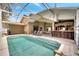 Backyard with a pool surrounded by outdoor seating and a charming tiki bar at 149 Imperial Oak Ct, Davenport, FL 33896