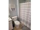 Bright bathroom featuring a toilet and shower with a decorative shower curtain at 153 Pompano Beach Dr Dr, Kissimmee, FL 34746