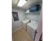 Well-lit laundry room equipped with a washer, dryer, and storage shelf at 153 Pompano Beach Dr Dr, Kissimmee, FL 34746