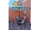 A patio with a striped umbrella, a glass-topped table, and seating for four, perfect for outdoor dining at 153 Pompano Beach Dr Dr, Kissimmee, FL 34746