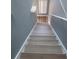 Staircase with light-colored treads, white risers and handrail, and gray walls at 153 Pompano Beach Dr Dr, Kissimmee, FL 34746